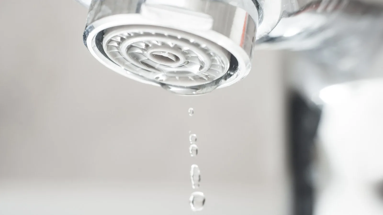 A single drop of water falling from a tap, frozen mid-air