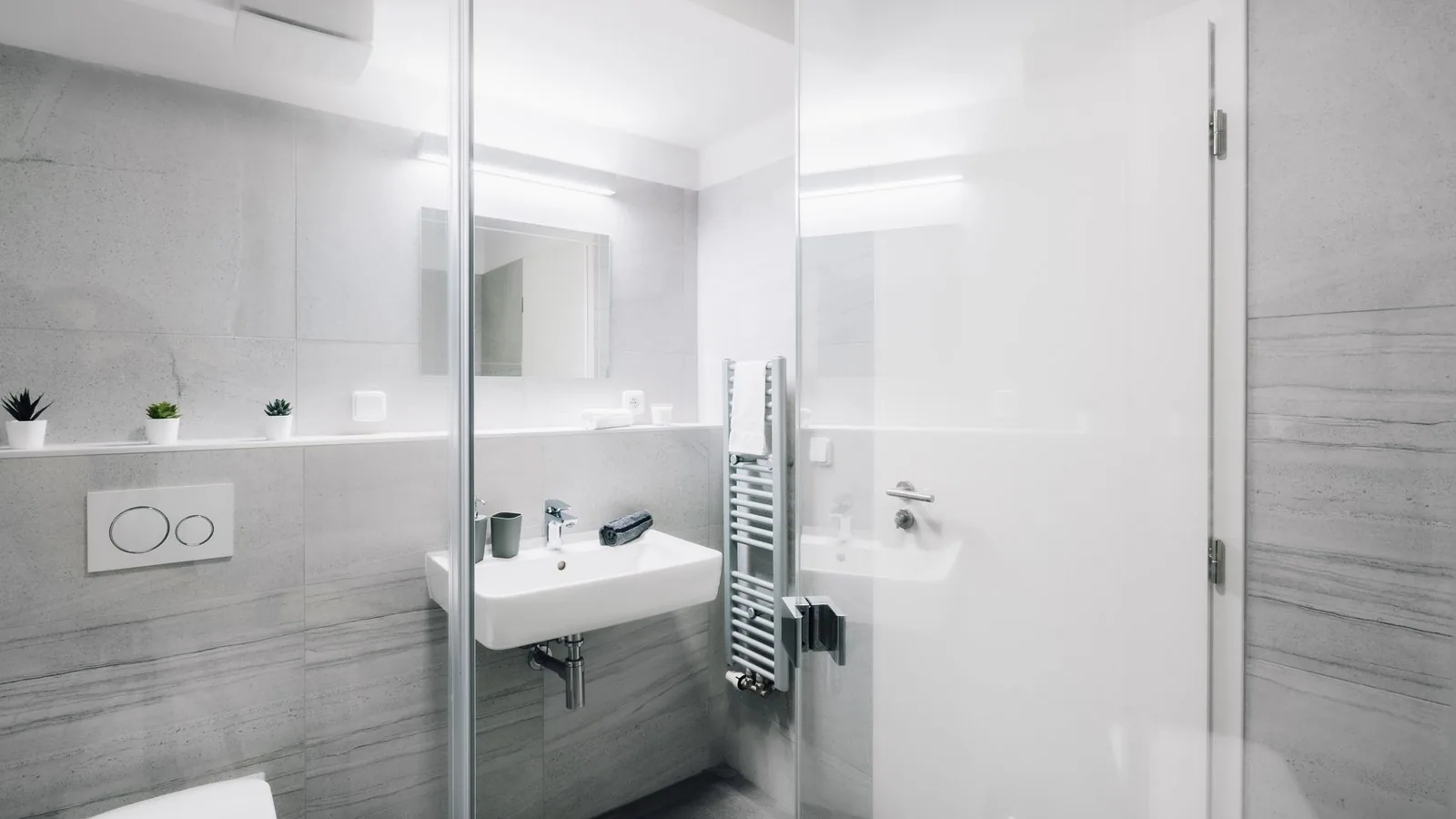Small rental bathroom with a glass shower enclosure and square sink
